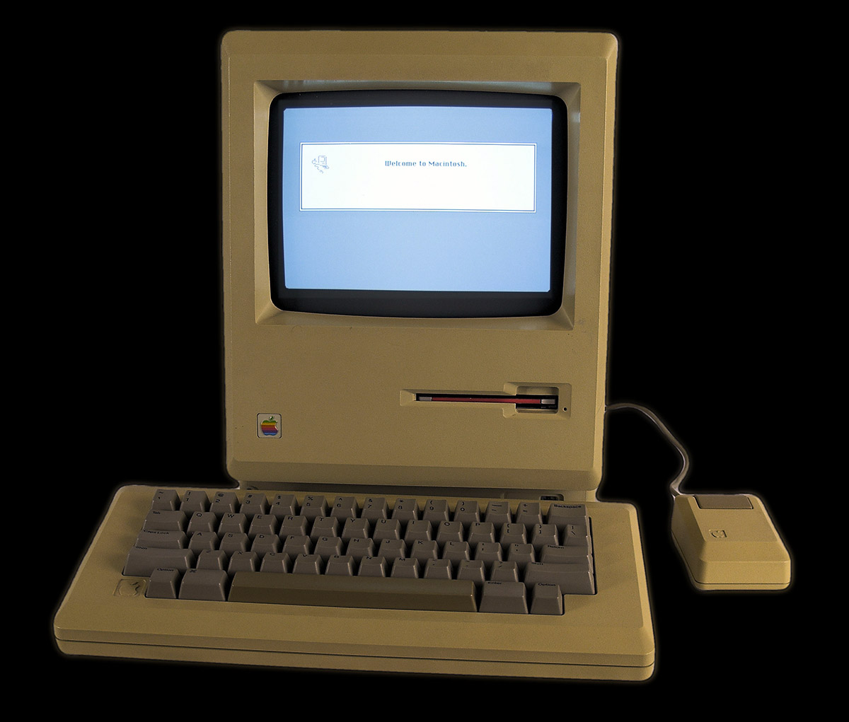 Original Apple Macintosh with mouse. Display says Welcome to Macintosh