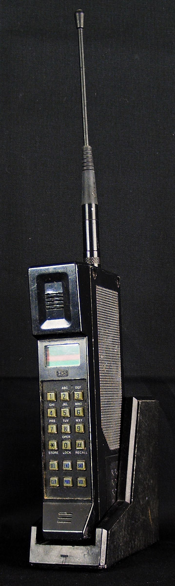 Handheld phone from late 1980s in charging cradle